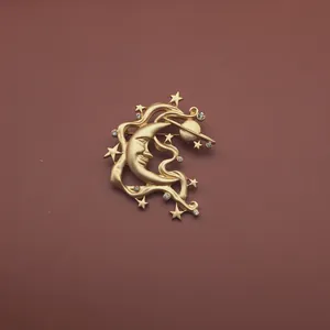 Detailansicht einer vergoldeten Vintage-Brosche mit Sichelmond und Sternenmuster.