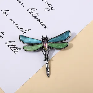 Detailed macro shot of vintage dragonfly brooch with colorful abalone shell inlays