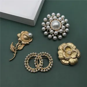 Detailed shot of vintage gold brooches with pearls and floral designs for elegant parties.