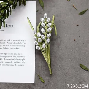 Macrodetail van handgemaakte vintage botanische groene parel tak broche speld voor dames