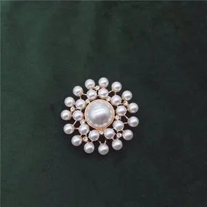 Detailed view of an elegant vintage Baroque pearl brooch on green velvet background