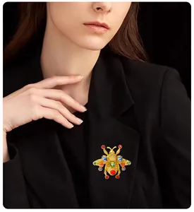 Primo piano di una spilla a ape vintage con cristalli colorati su un risvolto di blazer.