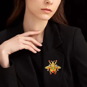 Elegante spilla ape vintage con cristalli colorati e placcatura oro su un blazer