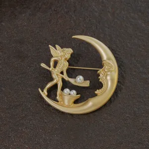 Elegant vintage golden baroque brooch featuring a crescent moon angel and pearls