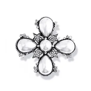 Macrobeeld van vintage barokke kruisbroche met grote parels en fonkelende strass sterdetails
