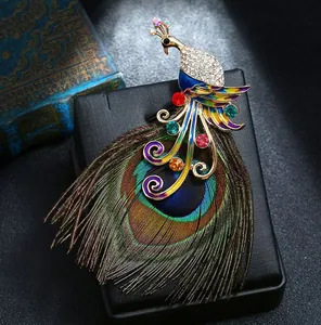 Elegante pauwenveer broche met sprankelende strass-steentjes en een vintage ontwerp.