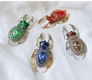 Detailed view of four colorful vintage beetle brooches with sparkling rhinestones