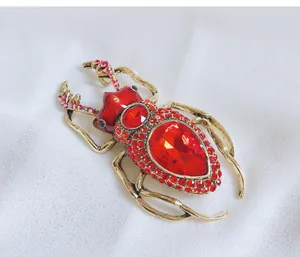 Detailed view of a vintage beetle brooch with sparkling red crystals and enamel