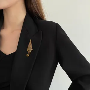Elegant golden umbrella crystal brooch accessory pinned on a professional black suit blazer