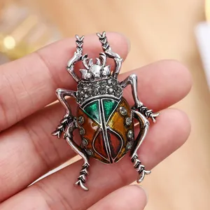Close-up of vintage beetle brooch with colorful enamel and rhinestone details