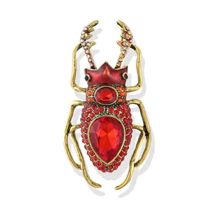 Vintage insect beetle brooch with red rhinestones and crystals on gold-tone metal