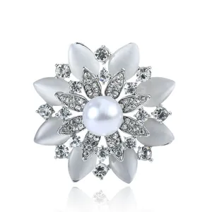 Detailed view of an elegant floral brooch with central pearl and sparkling rhinestones
