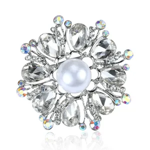 Close-up of an elegant silver brooch with pear-shaped crystals and central pearl
