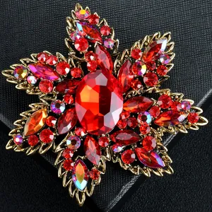 Detailed close-up of a luxurious floral brooch featuring vibrant red crystals and gold-tone metal