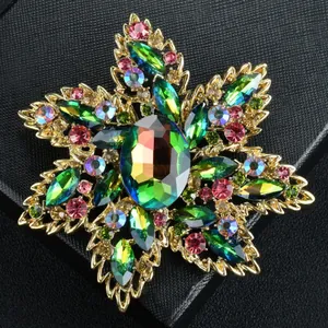Detailed macro view of a luxury flower brooch featuring vibrant green crystal stones.