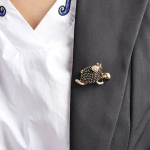 Macro detail view of a vintage walking turtle brooch pinned on a black suit jacket lapel