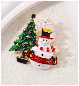 Gros plan d'une broche de Noël avec bonhomme de neige, sapin et bannière Let It Snow