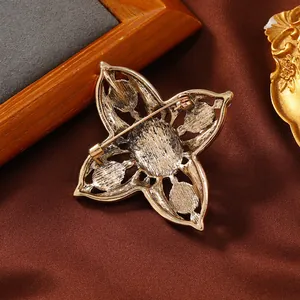 Rückansicht einer Vintage-Kreuzbrosche mit aufwendigem goldfarbenem Metallstift-Design