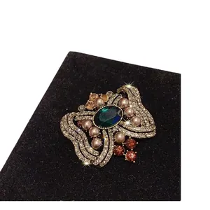 Broche de lazo de cristal de lujo vintage con piedra preciosa verde esmeralda y perlas