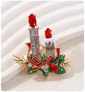 Détail d'une broche de Noël festive en forme de bougie avec des strass rouges brillants