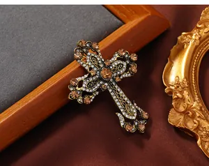 Exquisites Makro-Detail einer goldenen Vintage-Kreuzbrosche mit bernsteinfarbenen Kristallen
