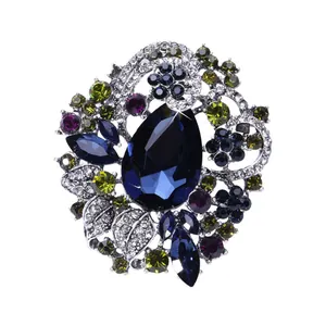 Gedetailleerd macrozicht van een vintage bohemien broche met een grote blauwe kristal.