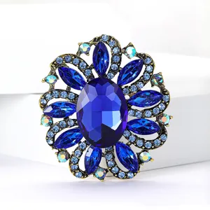Close-up of elegant vintage-style blue crystal flower brooch with rhinestone detailing.
