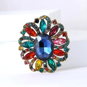 Detailed macro view of a vintage flower brooch with multi-colored crystals and blue stone