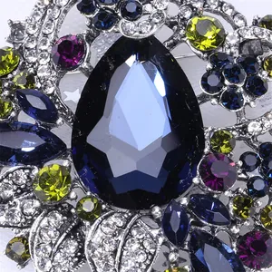 Macro-opname van een vintage boheemse broche met een groot peervormig blauw kristal.