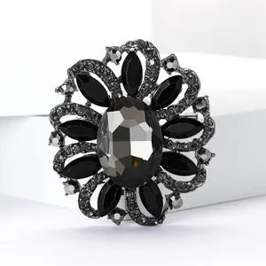 Detailed view of a vintage flower brooch with black and grey rhinestones in gunmetal frame