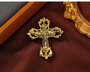 Detaillierte Rückansicht einer goldenen Vintage-Kreuzbrosche auf dunkelbraunem Stoff