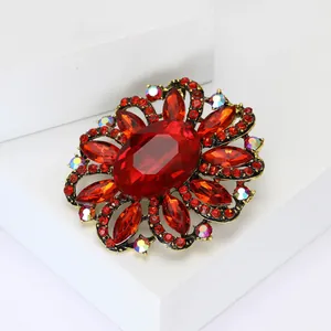 Detailed close-up of a vintage red crystal flower brooch with rhinestone accents
