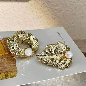 Gros plan de broches baroques vintage dorées avec perles et feuilles