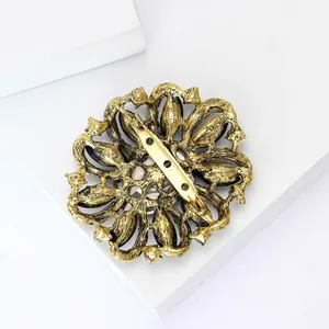Back view of a vintage alloy flower brooch with rhinestone detail and pin mechanism