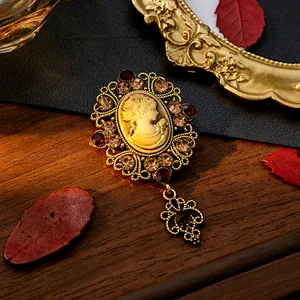 Gros plan détaillé d'une broche camée vintage avec filigrane doré et pierres précieuses