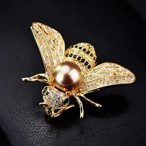 Macro detail of high-end insect bee brooch with zircon pavé and large pearl center