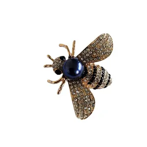 Detailed view of an elegant bee brooch with zircon wings and a navy pearl center.