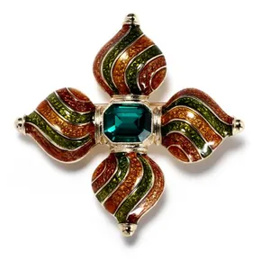 Detailed view of a baroque vintage brooch with emerald crystal and colorful enamel.
