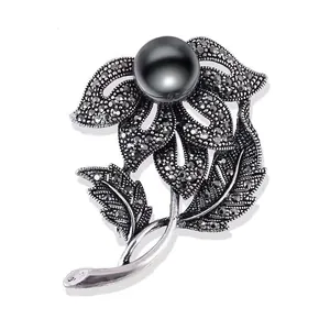 Detailaufnahme einer Vintage-Blumenbrosche mit schwarzer Perle und Markasit-Steinen