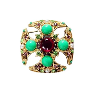 Detailed macro view of a baroque vintage brooch featuring colorful crystals and pearls decor.