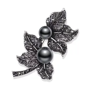 Nahaufnahme einer Vintage-Blattbrosche aus Legierung mit schwarzen Perlen und Strass