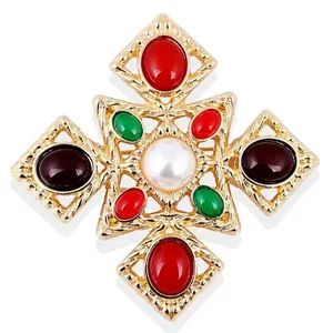 Detailed macro view of a vintage Baroque brooch with colorful crystals and center pearl.