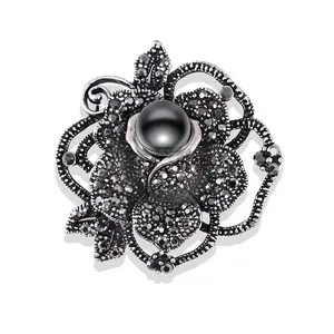 Detailansicht der eleganten Vintage-Rosenbrosche mit schwarzer Perle und Straß