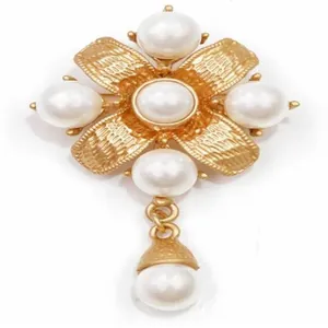 Exquisite close-up of a vintage baroque gold floral brooch adorned with elegant white pearls