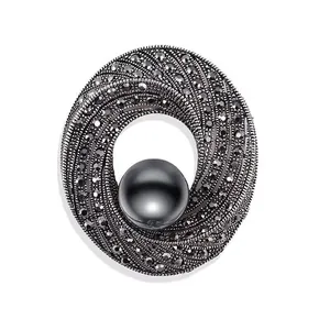 Detailaufnahme einer Vintage Brosche mit schwarzer Perle und funkelnden Strasssteinen