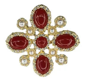 Detailed view of vintage baroque brooch featuring red stones, white pearls and crystals