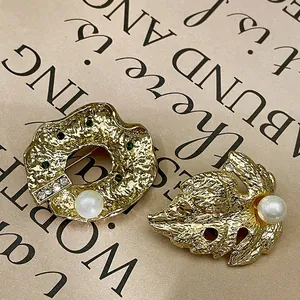 Gros plan détaillé de broches baroques vintage dorées avec perles et cristaux.