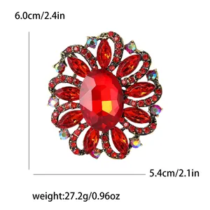 Elegant vintage flower brooch featuring vibrant red rhinestones and a large oval gemstone centerpiece