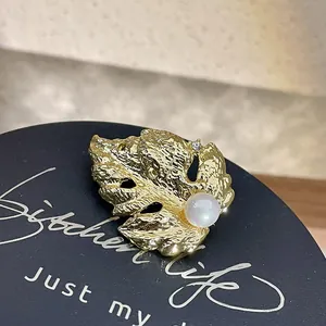 Gros plan d'une broche feuille d'or baroque vintage avec perle et cristal de luxe