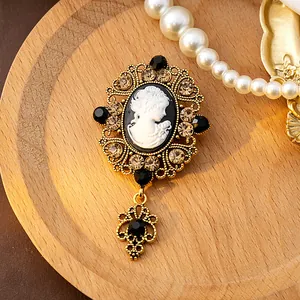 Détail d'une broche camée victorienne vintage avec cristaux et cadre doré raffiné.